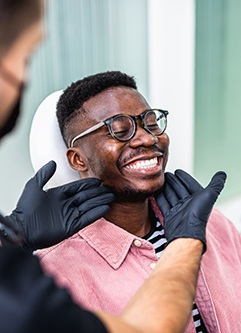 Dentist looking at patient's smile in treatment room