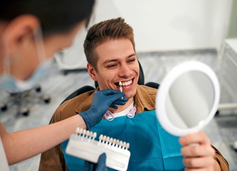 Man smiling while looking at reflection in mirror