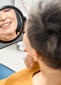 Mature dental patient smiling in mirror