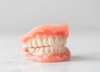 Full set of dentures against neutral background