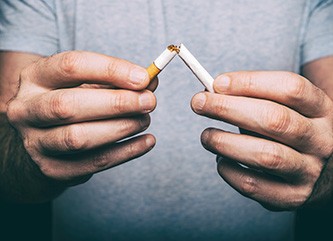 Male hands crushing a cigarette